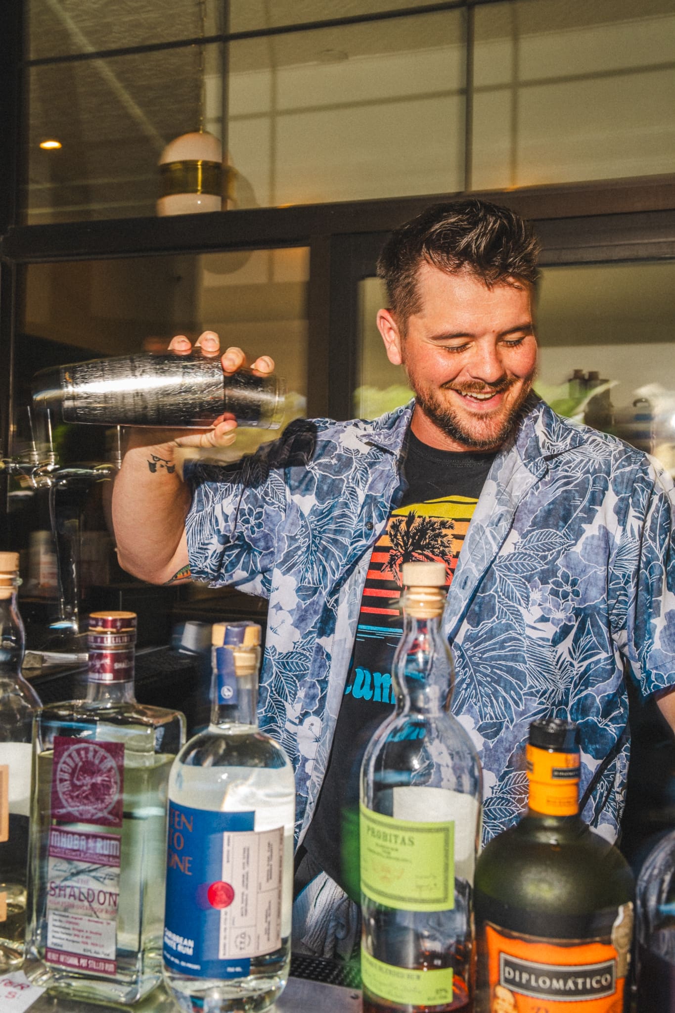 A bartender shaking a cocktail at the outdoor bar
